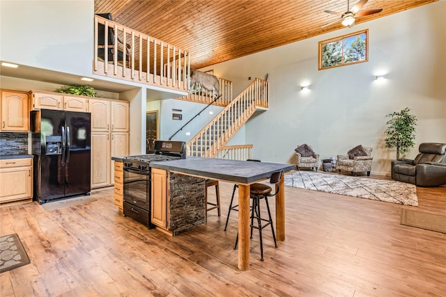 155 Grandview Ln, Seeley Lake, MT 59868 - kitchen featuring black appliances, wood ceiling, dark countertops, light brown cabinets, and light wood-style floors