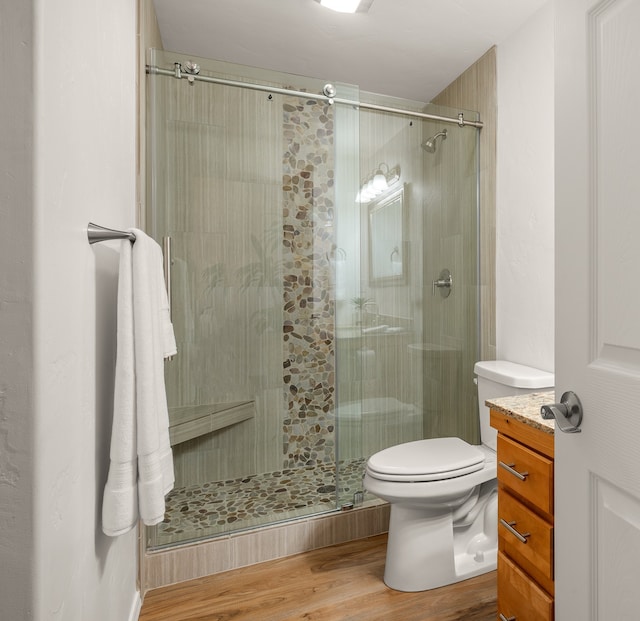 bathroom with hardwood / wood-style floors, vanity, toilet, and an enclosed shower