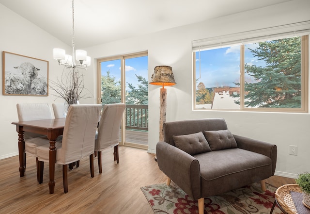 dining area featuring vaulted ceiling, a notable chandelier, and light hardwood / wood-style floors