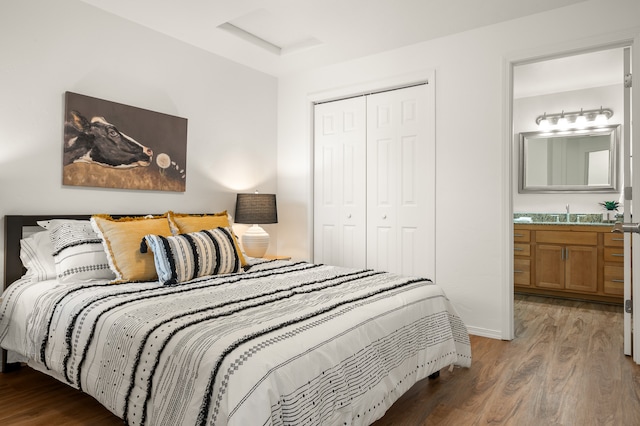 bedroom with sink, a closet, connected bathroom, and hardwood / wood-style floors