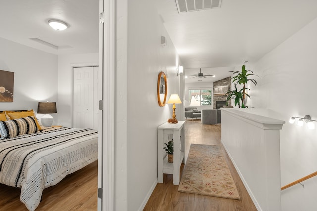 bedroom with light hardwood / wood-style flooring, a fireplace, and a closet