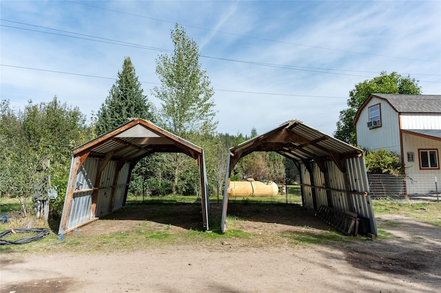 view of outbuilding with fence and a detached carport