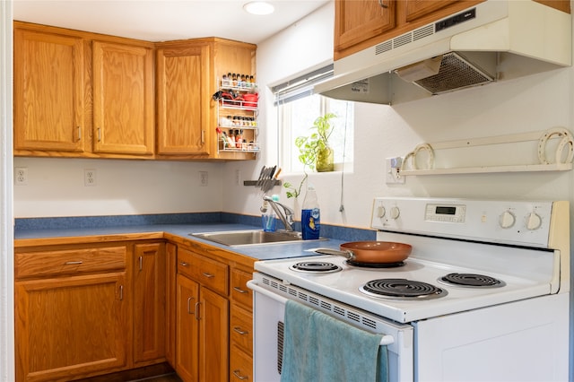 kitchen with under cabinet range hood, white electric stove, brown cabinetry, and a sink