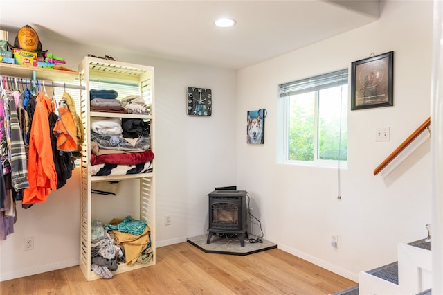 interior space featuring light wood finished floors, a wood stove, and baseboards