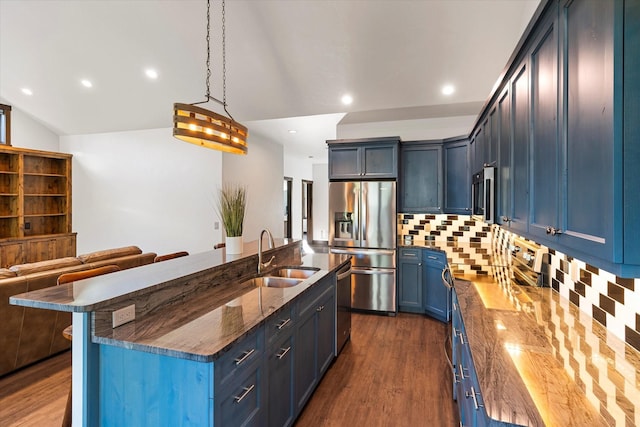 kitchen with blue cabinetry, a kitchen island with sink, stainless steel appliances, hanging light fixtures, and sink