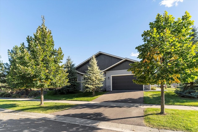 obstructed view of property with a garage and a front lawn