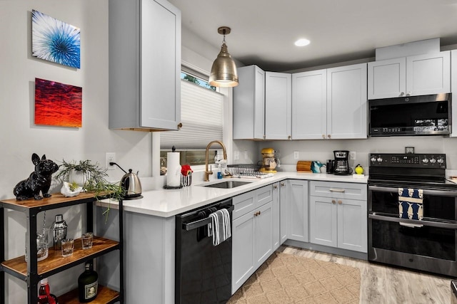 1010 7th St E Unit A, Whitefish, MT 59937 - kitchen with black appliances, a sink, light countertops, light wood-type flooring, and hanging light fixtures