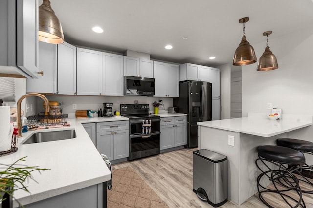 1010 7th St E Unit A, Whitefish, MT 59937 - kitchen with range with two ovens, a sink, black fridge with ice dispenser, a breakfast bar area, and a peninsula