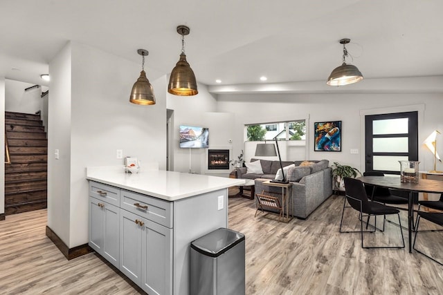 1010 7th St E Unit A, Whitefish, MT 59937 - kitchen with gray cabinetry, light wood-style floors, light countertops, pendant lighting, and open floor plan