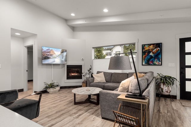 living room featuring light hardwood / wood-style floors and high vaulted ceiling