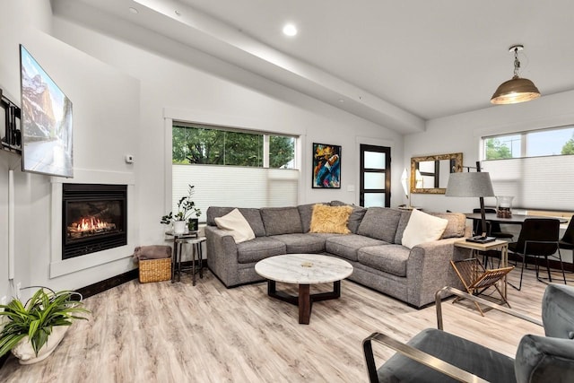 1010 7th St E Unit A, Whitefish, MT 59937 - living area featuring a glass covered fireplace, vaulted ceiling, light wood finished floors, and recessed lighting