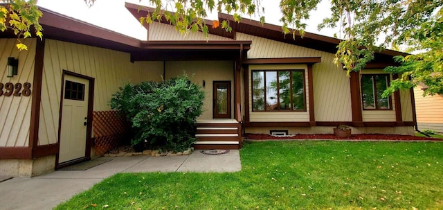 view of exterior entry with a lawn