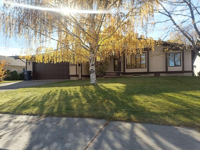 view of front facade featuring a garage, driveway, a front yard, and entry steps