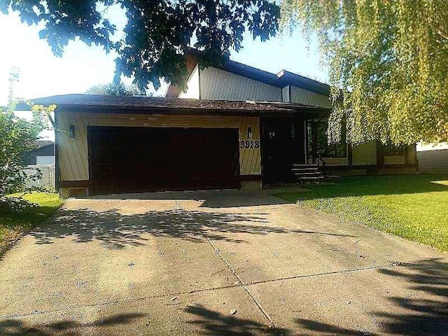 manufactured / mobile home featuring a front yard and a garage