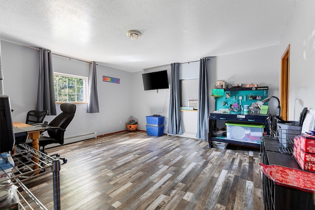 office space with a textured ceiling, a baseboard heating unit, and hardwood / wood-style flooring