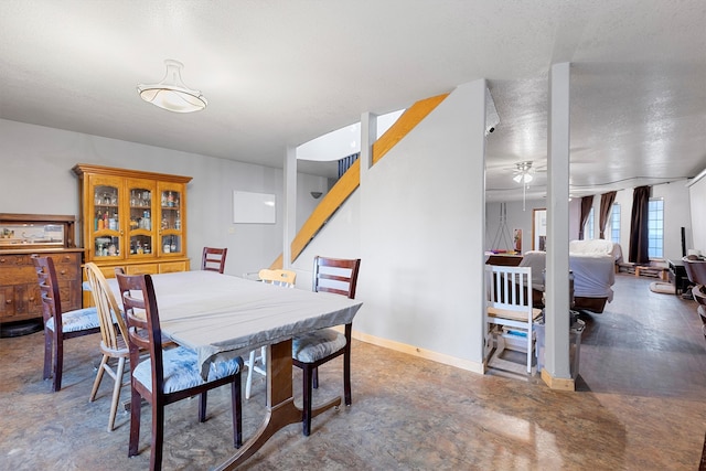 dining space featuring ceiling fan and a textured ceiling