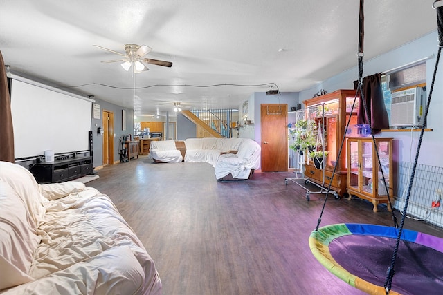 living room featuring ceiling fan, a textured ceiling, and dark hardwood / wood-style floors