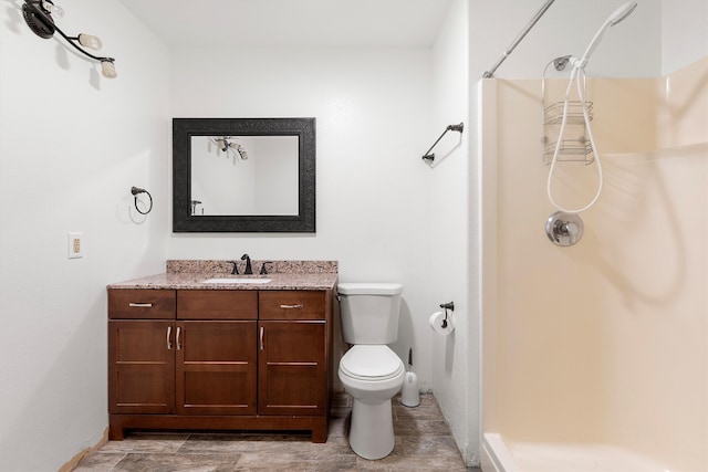 bathroom with walk in shower, vanity, and toilet