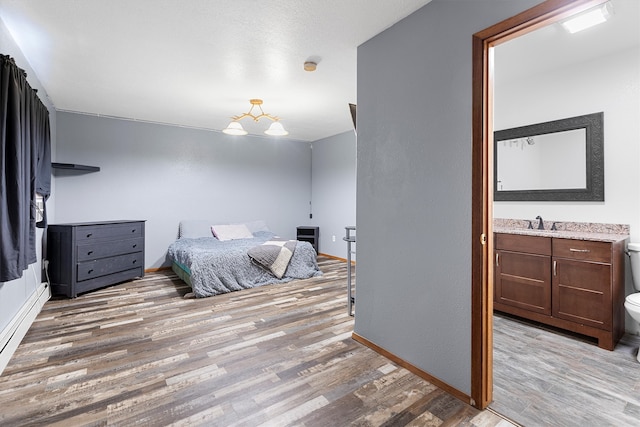 bedroom featuring light wood-type flooring and sink