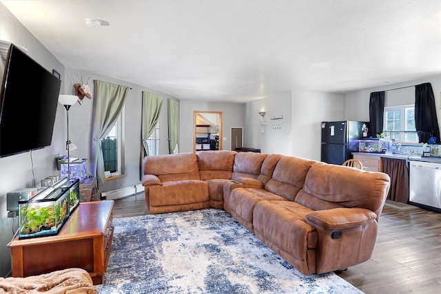 living room with a textured ceiling, a baseboard heating unit, and hardwood / wood-style flooring