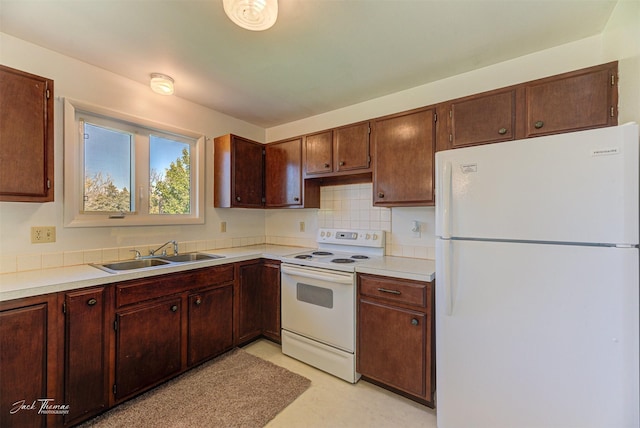 kitchen with light countertops, decorative backsplash, a sink, and white appliances