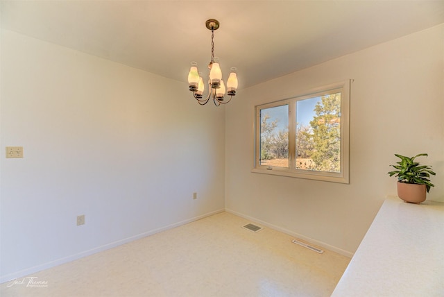 unfurnished room with visible vents, baseboards, and a notable chandelier