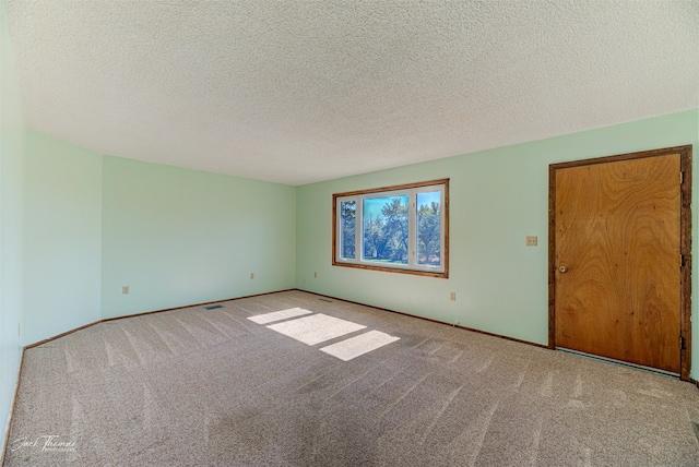 carpeted empty room featuring a textured ceiling