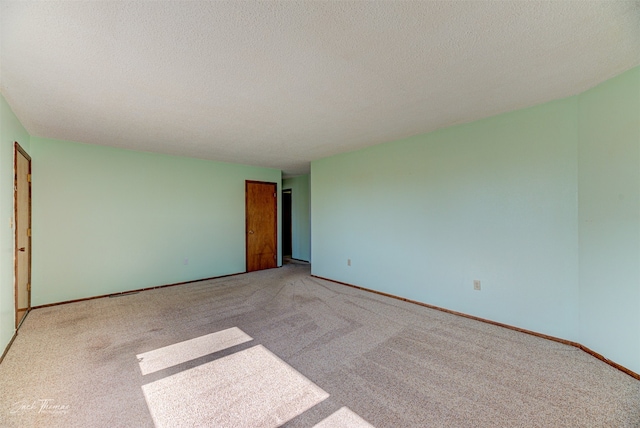 unfurnished bedroom with light carpet and a textured ceiling