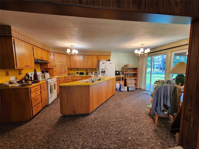 kitchen with a notable chandelier, dark colored carpet, white appliances, and a center island