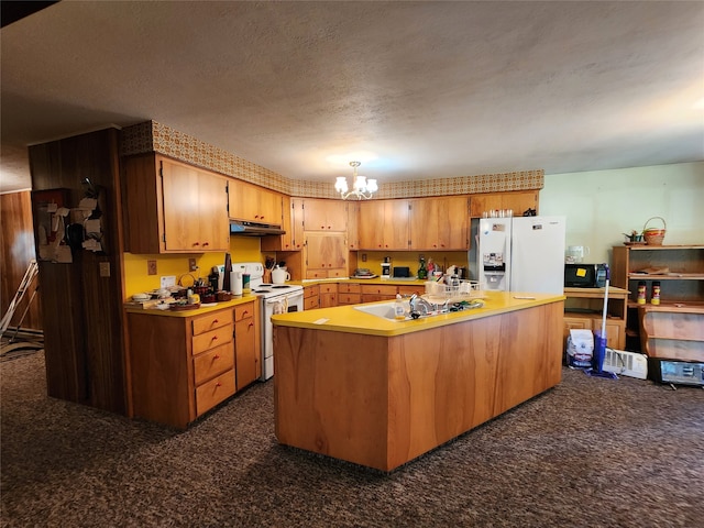 kitchen featuring dark carpet, a chandelier, a textured ceiling, a center island, and white appliances