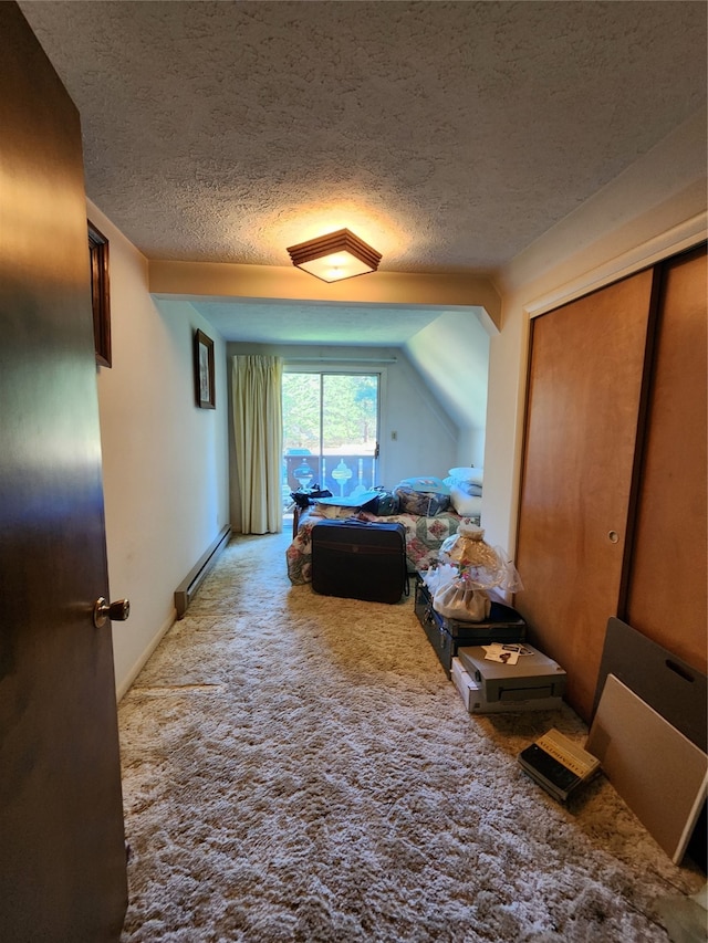 bedroom featuring vaulted ceiling, carpet floors, baseboard heating, a closet, and a textured ceiling