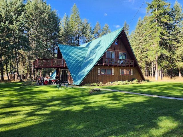 rear view of property with a wooden deck and a yard