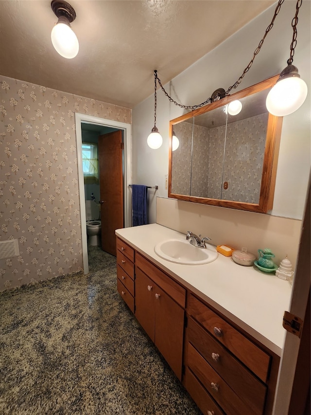 bathroom featuring vanity, toilet, and a textured ceiling