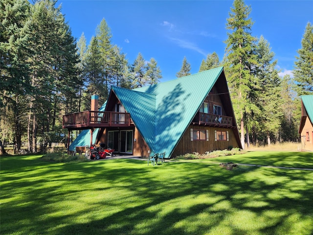 rear view of property featuring a yard and a wooden deck