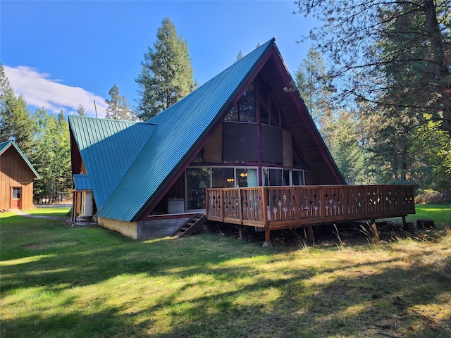 back of property with a deck and a lawn