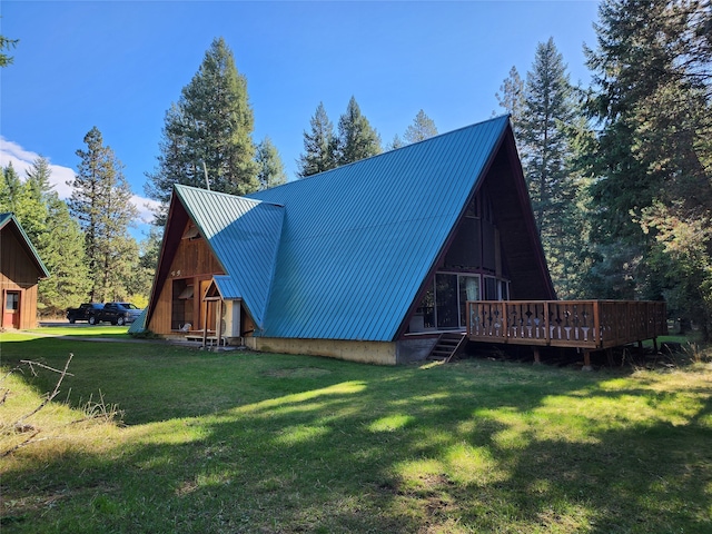 rear view of property featuring a lawn and a deck