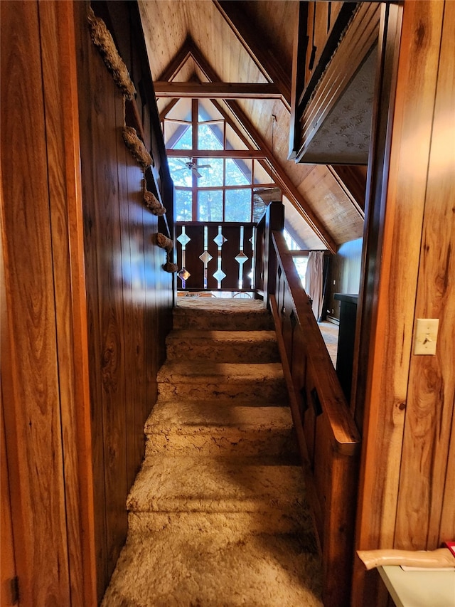 stairs featuring vaulted ceiling, wooden walls, and hardwood / wood-style floors