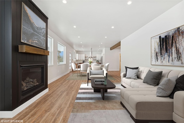 living room featuring light wood-type flooring and a large fireplace