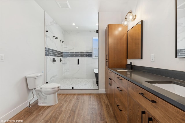 bathroom with a shower with shower door, hardwood / wood-style floors, toilet, and vanity