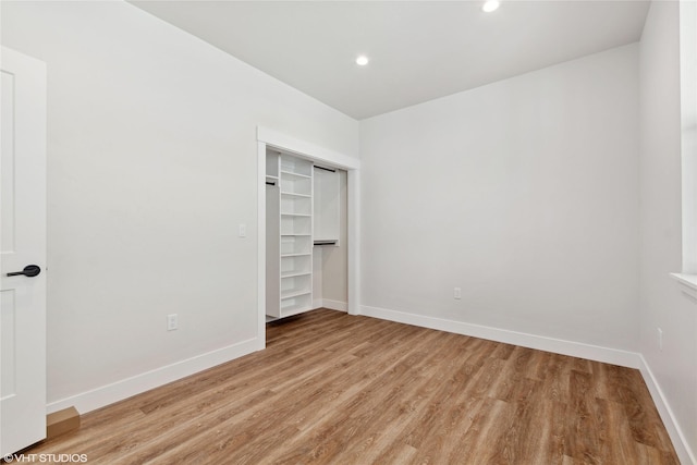 unfurnished bedroom featuring a closet and light wood-type flooring