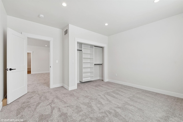 unfurnished bedroom featuring light colored carpet and a closet