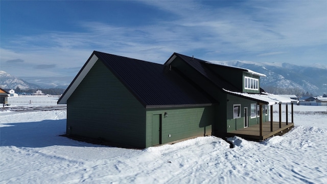 view of snow covered exterior featuring a mountain view