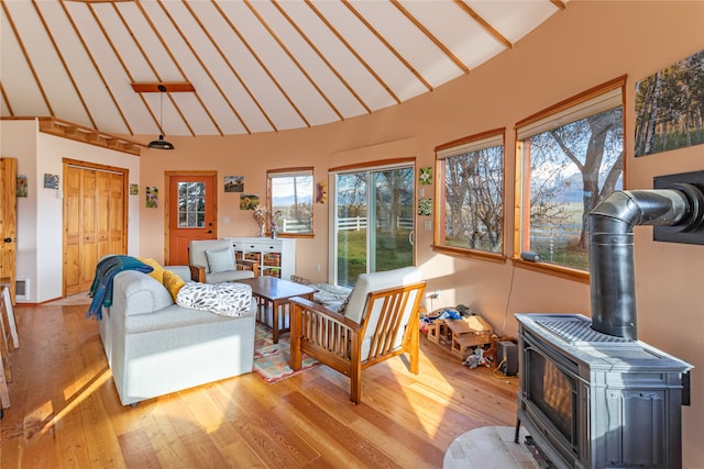 sunroom with vaulted ceiling and a wood stove