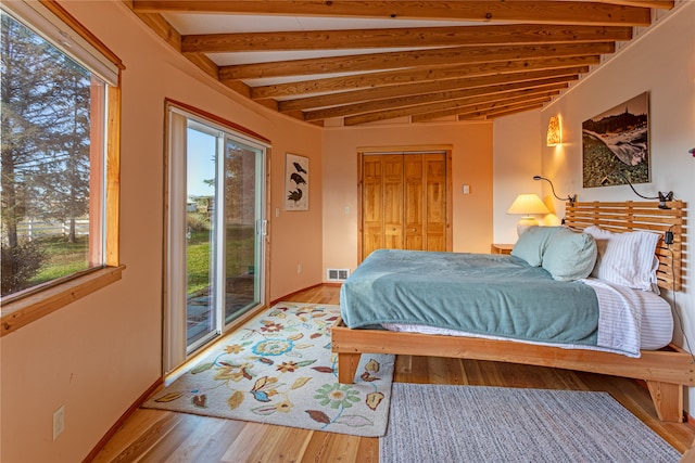 bedroom featuring beamed ceiling, light wood-type flooring, and access to outside