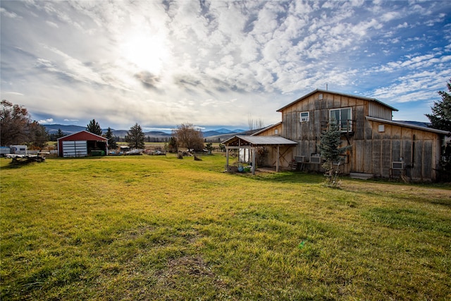 view of yard featuring a garage, a mountain view, and an outbuilding