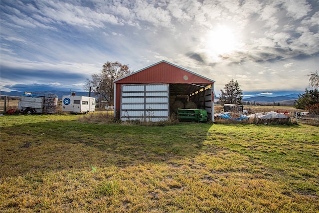 view of outbuilding featuring a mountain view and a yard