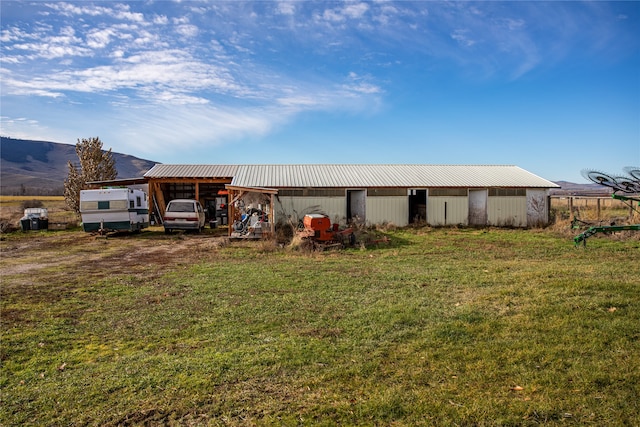 view of outbuilding with a yard and a mountain view