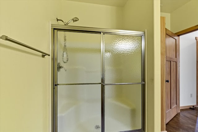 bathroom with walk in shower and wood-type flooring