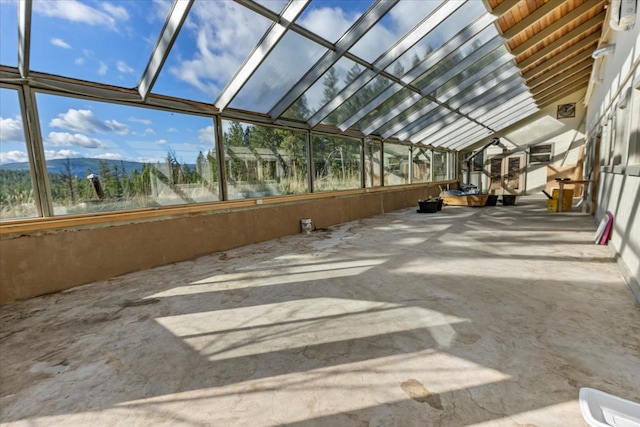 unfurnished sunroom featuring vaulted ceiling and a mountain view