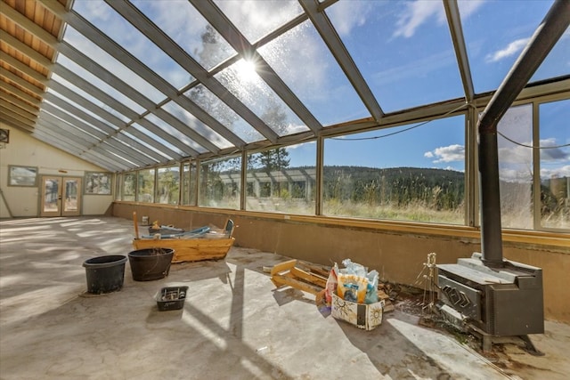 sunroom / solarium featuring vaulted ceiling and a wood stove